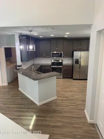 a kitchen with stainless steel appliances granite countertop a sink and a refrigerator