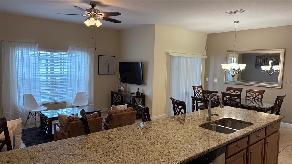 4794 Clock Tower Drive Kissimmee, FL 34746 - Photo 12 of 63 a kitchen with kitchen island granite countertop a sink a counter top space and stainless steel appliances