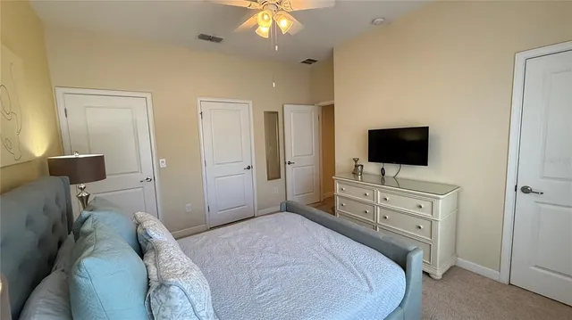 a bedroom with a bed and a flat tv screen on dresser