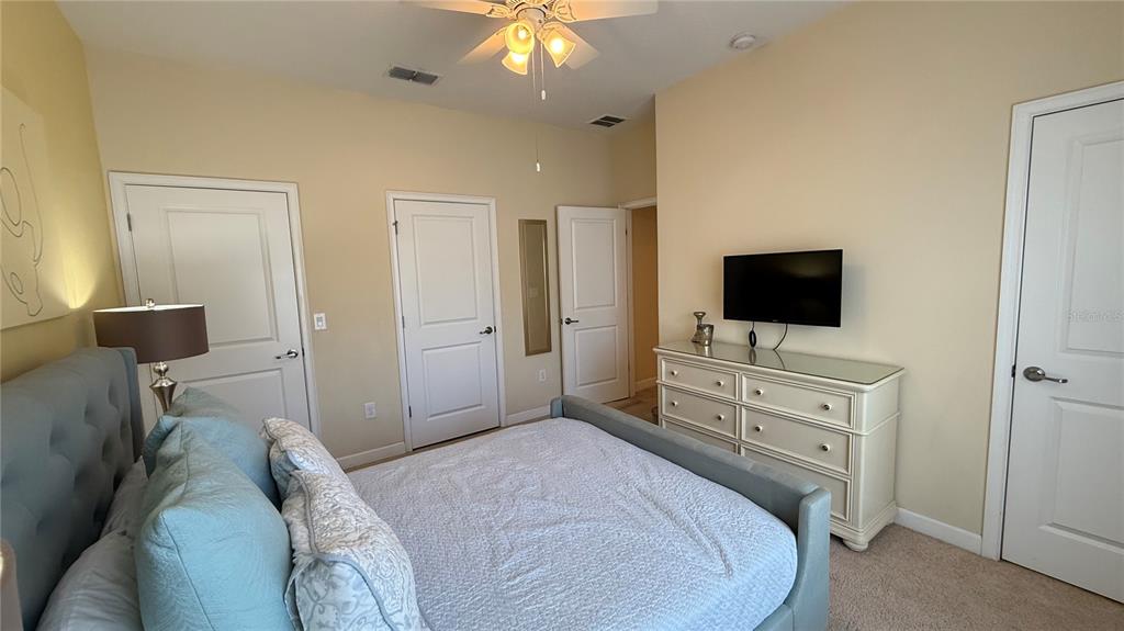 4794 Clock Tower Drive Kissimmee, FL 34746 - Photo 16 of 63 a bedroom with a bed and a flat screen tv