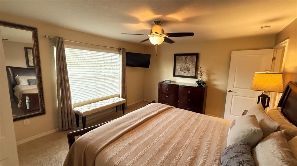 4794 Clock Tower Drive Kissimmee, FL 34746 - Photo 20 of 63 a bedroom with a bed and a chandelier