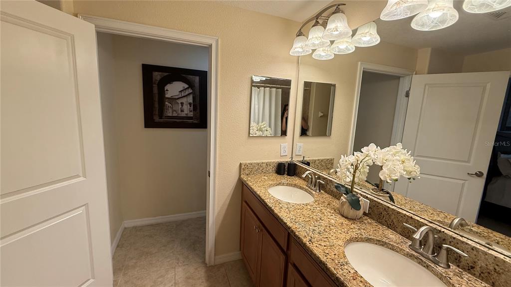 4794 Clock Tower Drive Kissimmee, FL 34746 - Photo 23 of 63 a bathroom with a granite countertop sink a large mirror and a shower