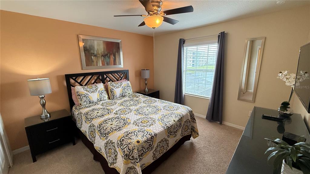 4794 Clock Tower Drive Kissimmee, FL 34746 - Photo 26 of 63 a bedroom with a bed and a chandelier