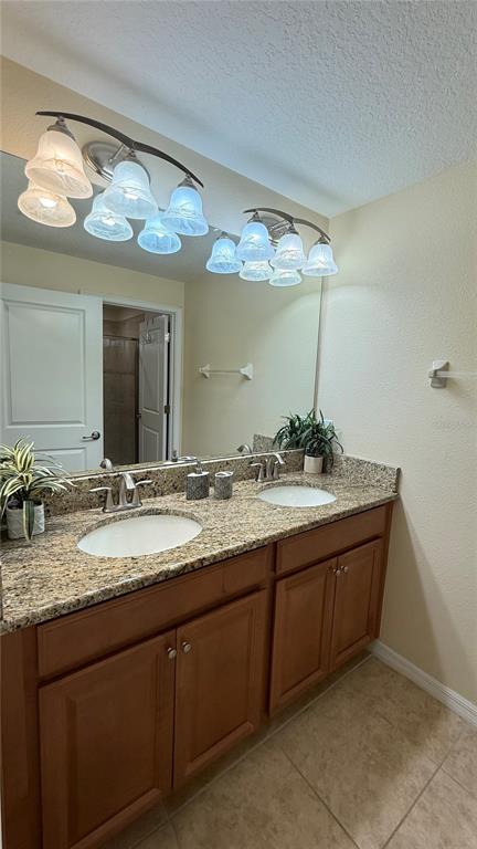 4794 Clock Tower Drive Kissimmee, FL 34746 - Photo 28 of 63 a bathroom with a granite countertop sink a large mirror and a