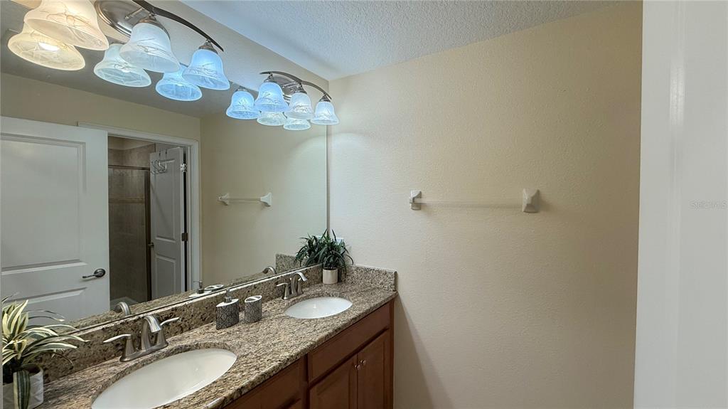 4794 Clock Tower Drive Kissimmee, FL 34746 - Photo 29 of 63 a bathroom with a granite countertop sink and a mirror