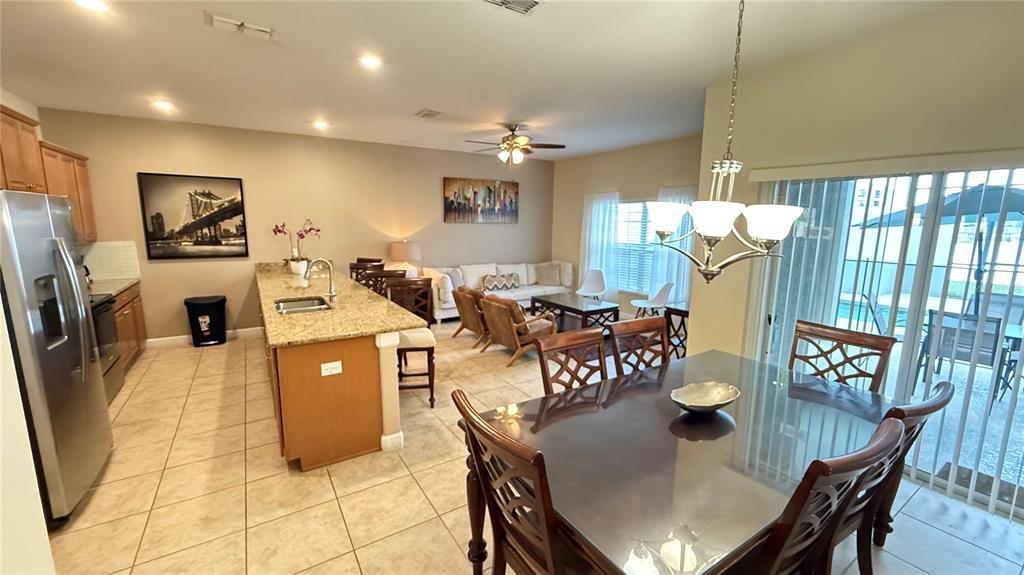 4794 Clock Tower Drive Kissimmee, FL 34746 - Photo 3 of 63 a living room with dining table and a refrigerator