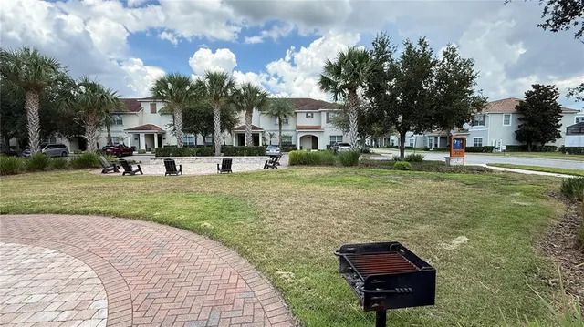 a sign board with a house and yard in the back