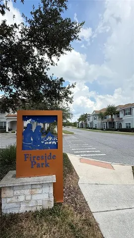 a sign board with a house in the background