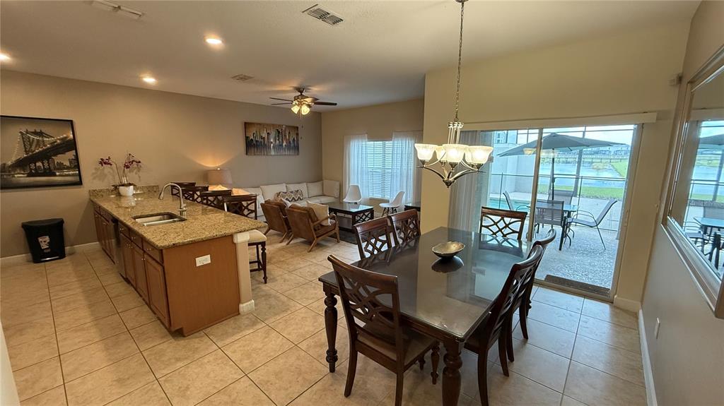 4794 Clock Tower Drive Kissimmee, FL 34746 - Photo 9 of 63 a living room with furniture a floor to ceiling window and a flat screen tv