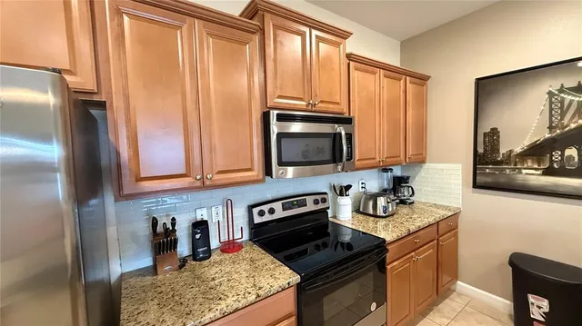 a kitchen with kitchen island granite countertop a sink a counter top space and stainless steel appliances