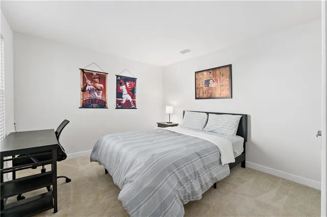 a bedroom with bed and painting on the wall