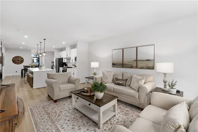 a living room with furniture and view of kitchen