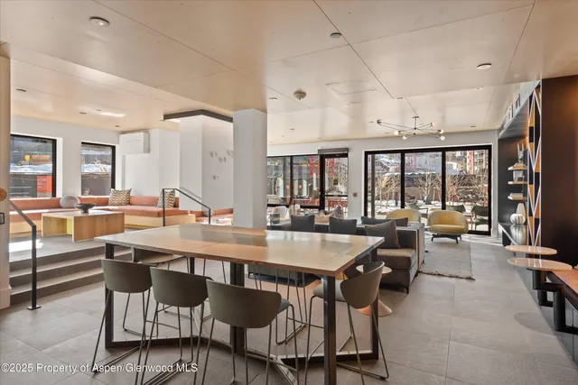 a dining hall with stainless steel appliances kitchen island granite countertop a table and chairs