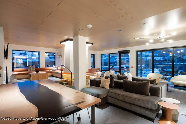 a living room with furniture fireplace and large windows
