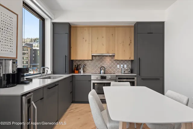a kitchen with a sink a stove and white cabinets