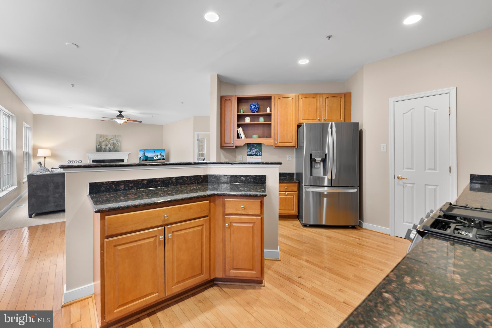 934 Zenith Drive Freeland, MD 21053 - Photo 15 of 50 a kitchen with stainless steel appliances granite countertop a refrigerator a stove and a sink with wooden floors