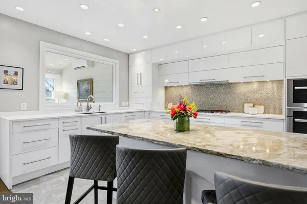 a dining room with furniture a wooden floor and a kitchen view