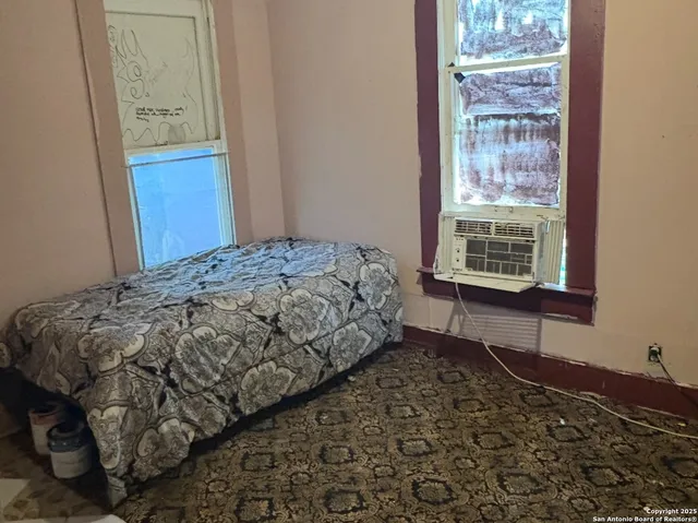 a bed sitting in a bedroom next to a window