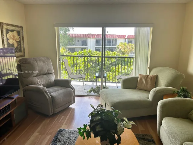 a living room with furniture and a floor to ceiling window