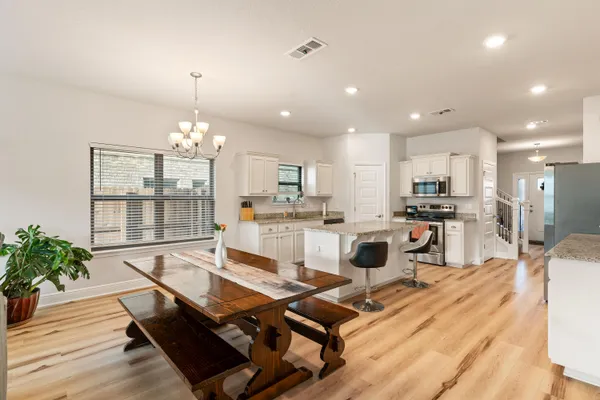 a living room with furniture a chandelier and a flat screen tv