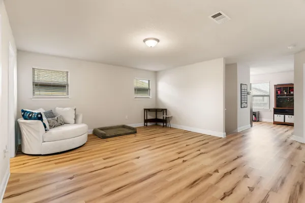 a view of an empty room with wooden floor