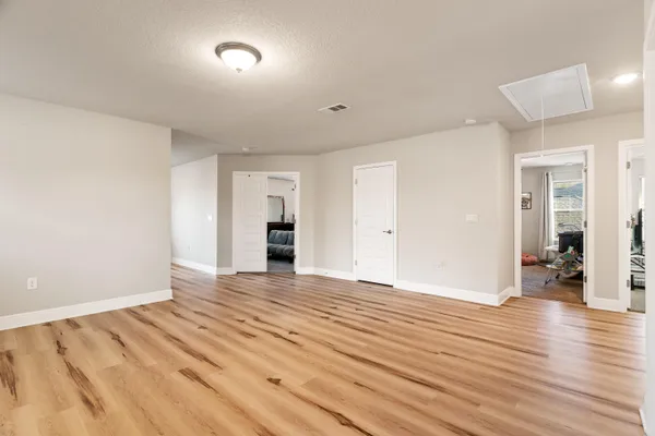 a view of an empty room with wooden floor