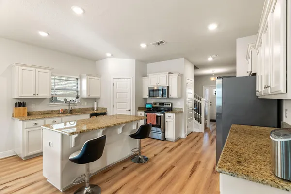 a kitchen with stainless steel appliances granite countertop a refrigerator stove microwave and sink