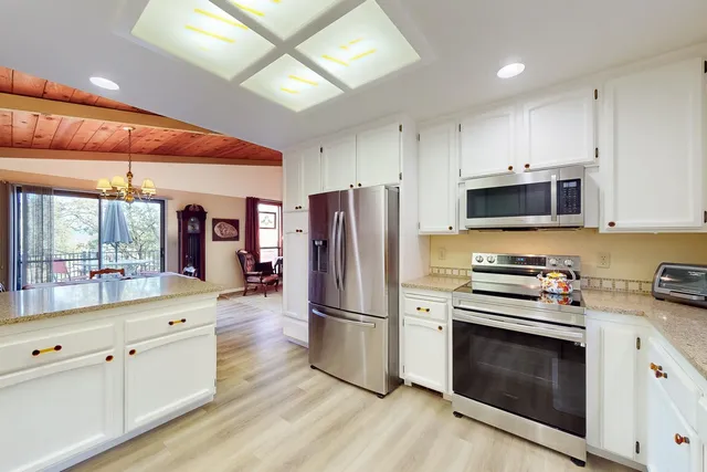 a kitchen with stainless steel appliances a stove a refrigerator and a microwave