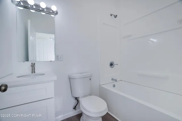 a white toilet sitting next to a bathroom sink and vanity