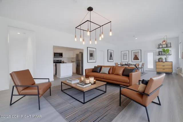 a living room with furniture a rug and white walls