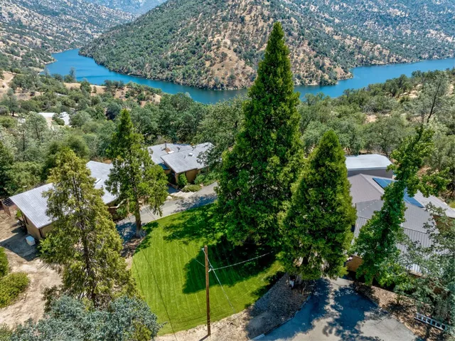 an aerial view of residential house with outdoor space and trees all around