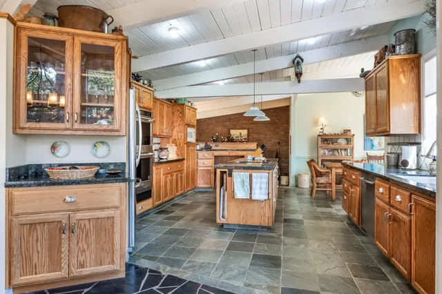a kitchen with stainless steel appliances granite countertop a sink a stove and a refrigerator
