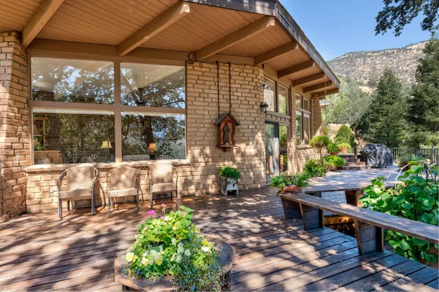 a view of balcony with wooden floor and fence