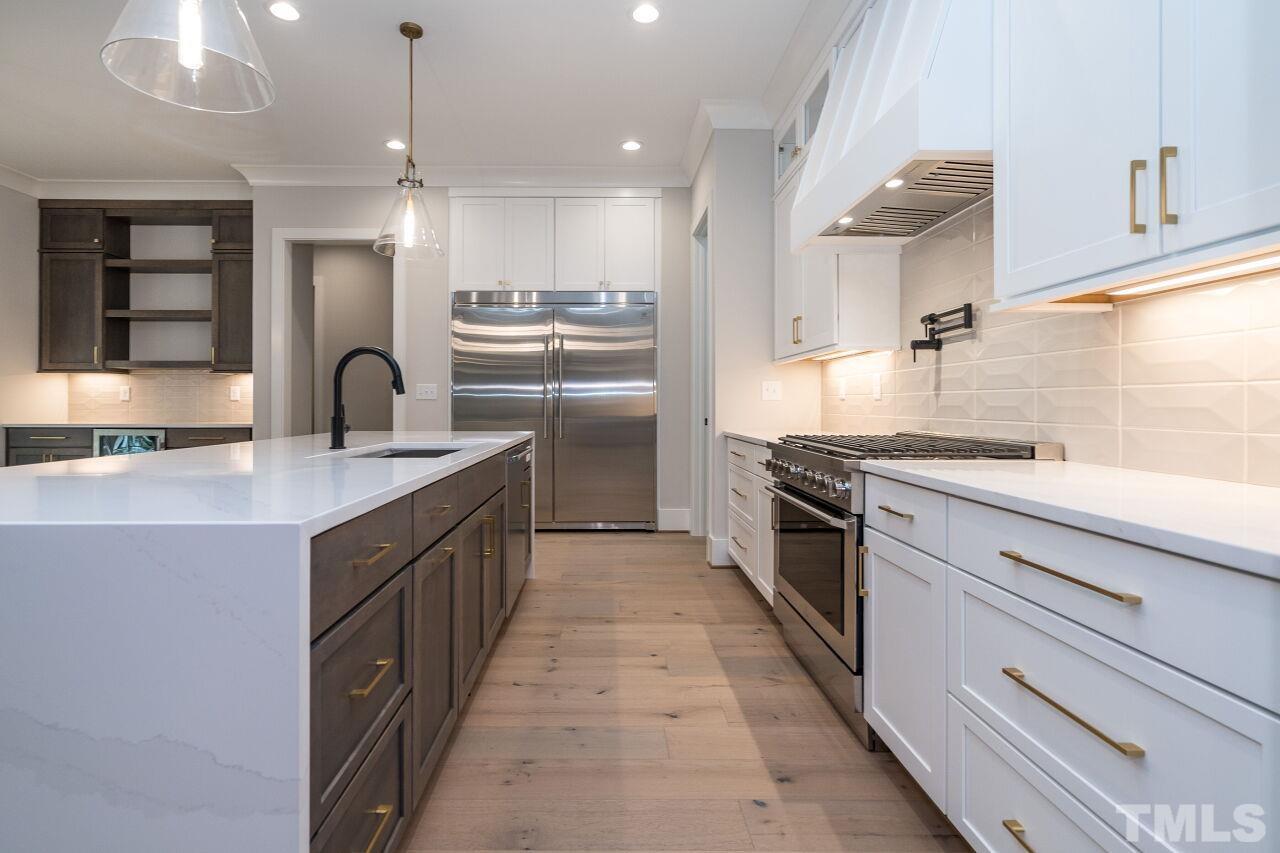 1220 Explorer Trail Wake Forest, NC 27587 - Photo 16 of 49 a kitchen with kitchen island granite countertop a sink a counter top space stainless steel appliances and cabinets