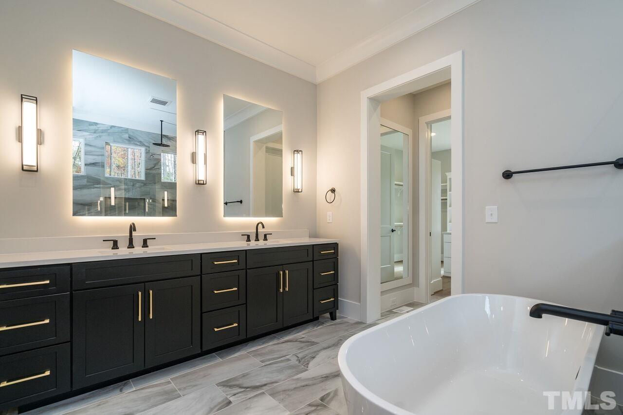 1220 Explorer Trail Wake Forest, NC 27587 - Photo 26 of 49 a bathroom with a tub a double vanity sink and mirror