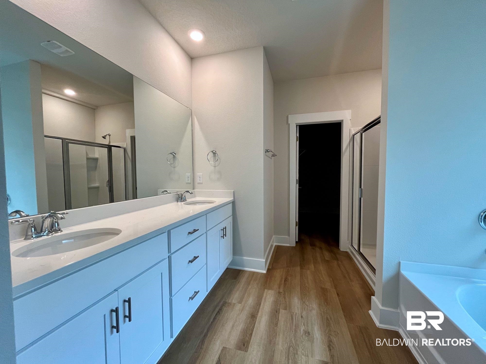 330 Barndling Street Fairhope, AL 36532 - Photo 24 of 31 Bathroom featuring vanity, plus walk in shower, a textured ceiling, and hardwood / wood-style flooring