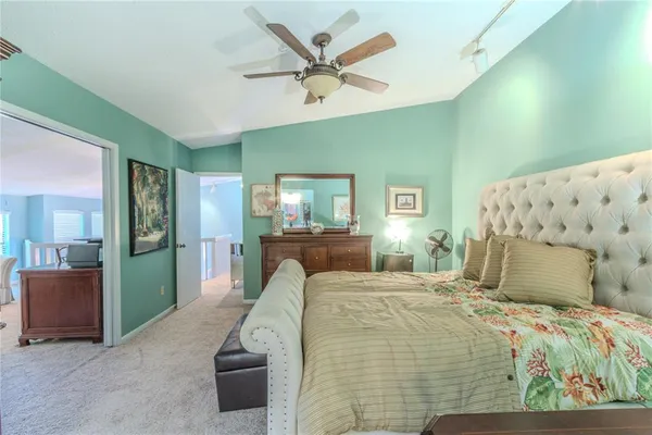 a bedroom with a large bed and a chandelier