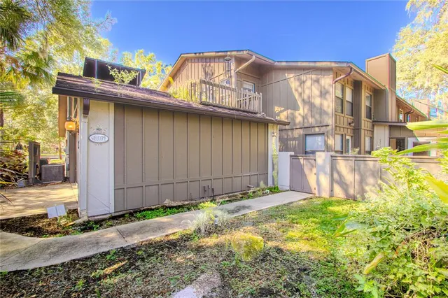 a view of a house with a small yard and wooden fence