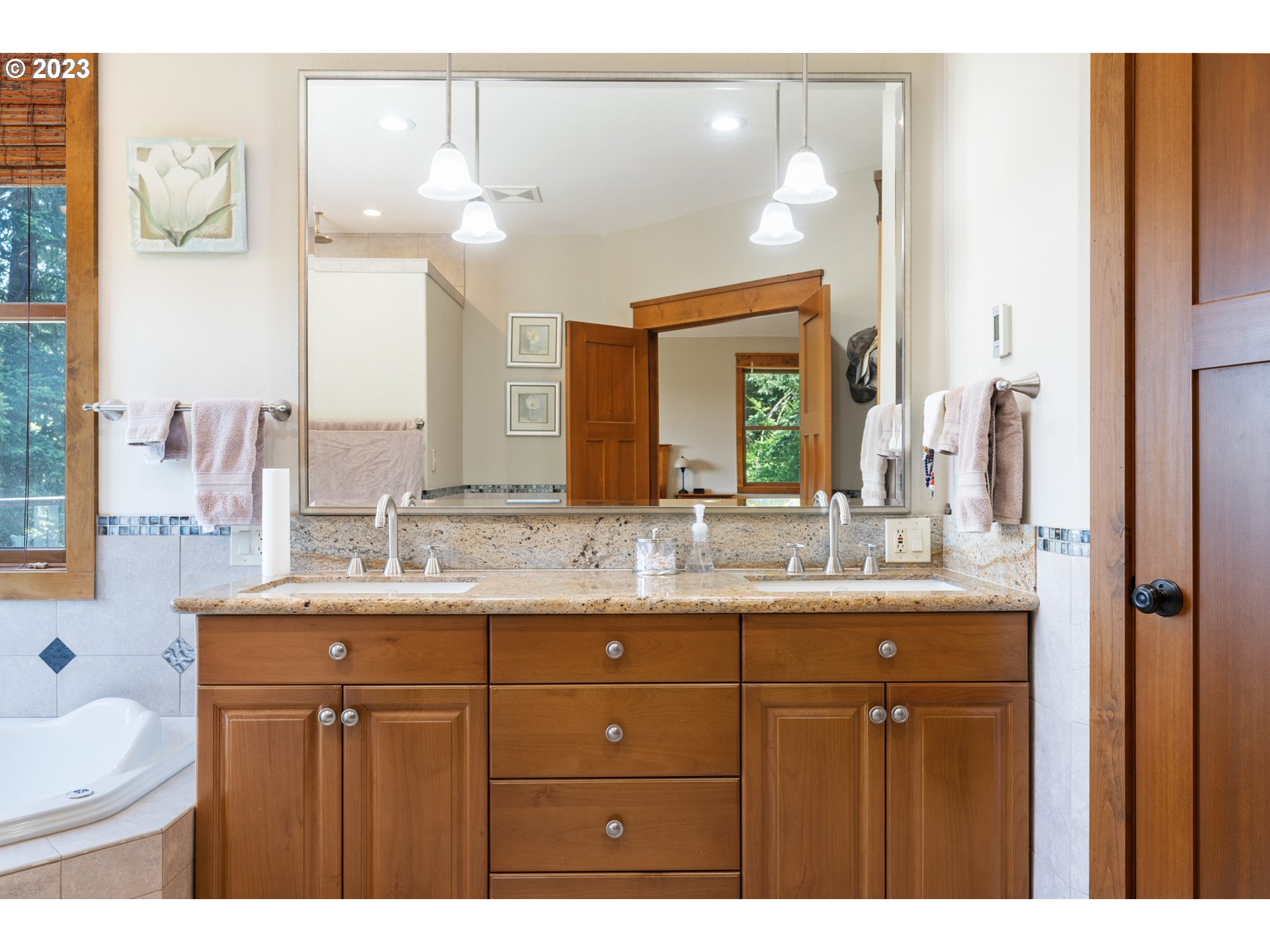 10534 Southeast Vradenburg Road Happy Valley, OR 97086 - Photo 13 of 39 a bathroom with a granite countertop sink a large mirror and a shower