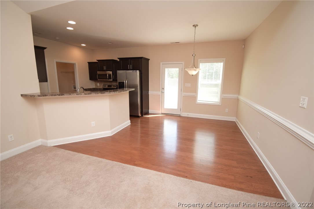 115 Snipe Court Raeford, NC 28376 - Photo 12 of 37 a view of a kitchen with a stove cabinets and a wooden floor