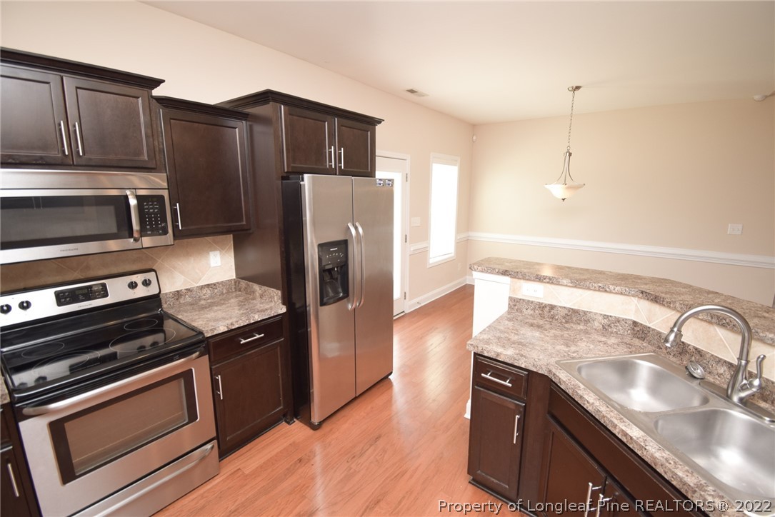 115 Snipe Court Raeford, NC 28376 - Photo 14 of 37 a kitchen with granite countertop a refrigerator stove and sink