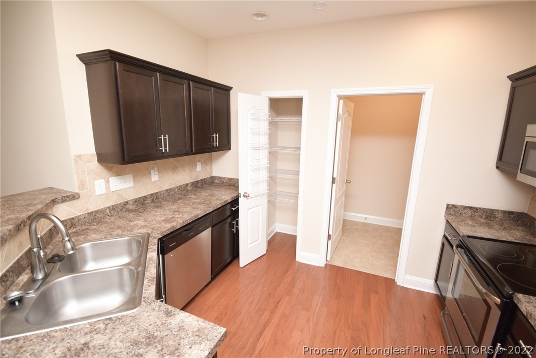 115 Snipe Court Raeford, NC 28376 - Photo 20 of 37 a kitchen with granite countertop wooden cabinets and a stove top oven