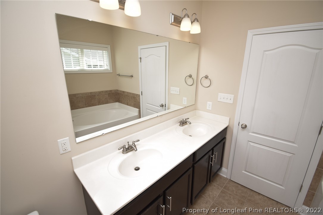 115 Snipe Court Raeford, NC 28376 - Photo 29 of 37 a bathroom with a sink a mirror and a shower
