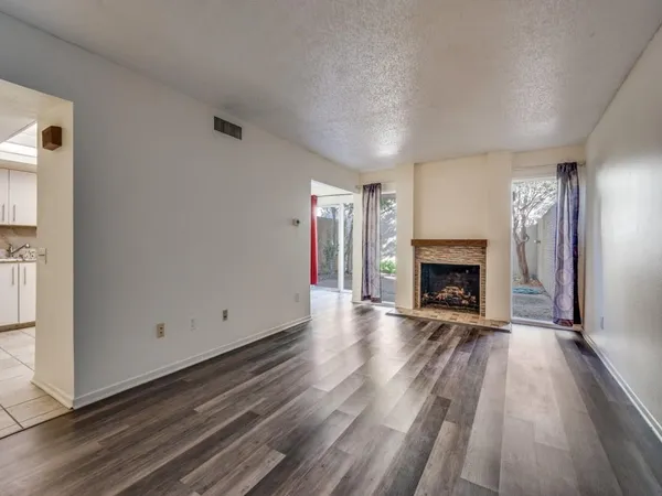a view of a livingroom with wooden floor and a fireplace