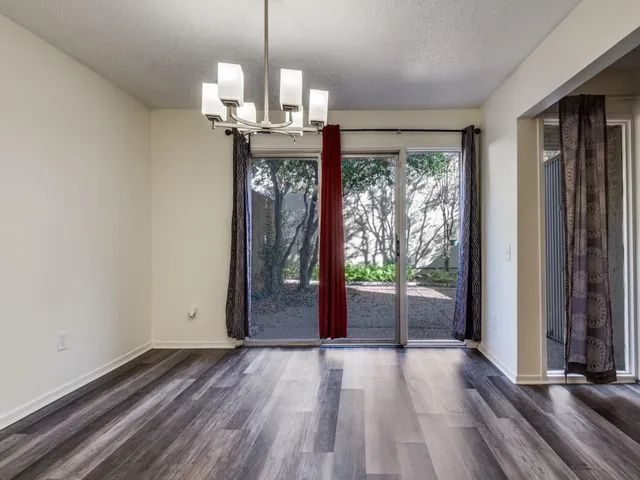 a view of a room with wooden floor stairs and a chandelier