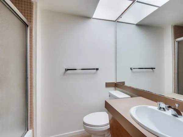 a bathroom with a sink a toilet and a mirror