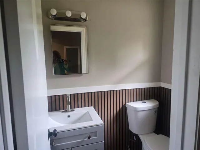 a bathroom with a toilet a sink and mirror