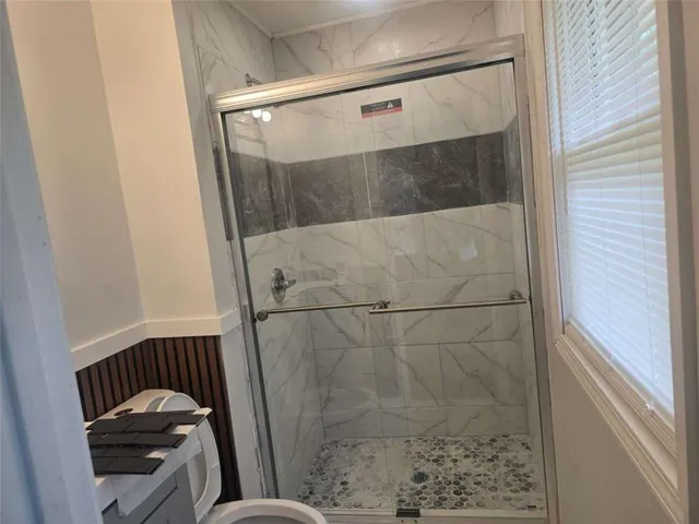 a bathroom with a toilet and a shower