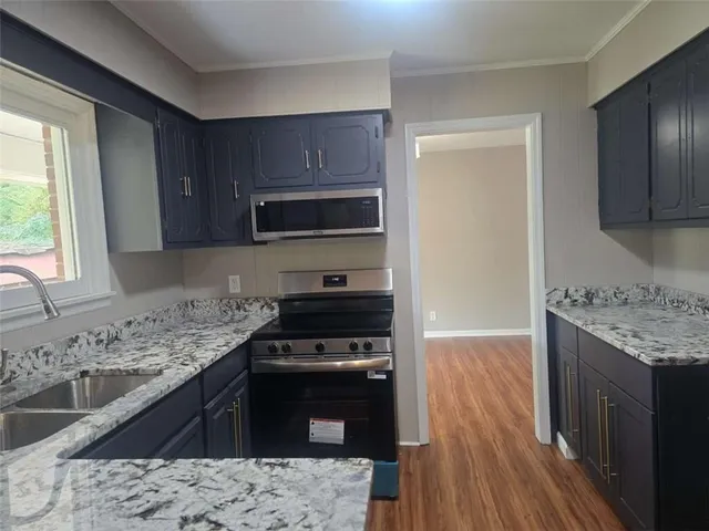 a kitchen with a sink stove top oven and cabinets