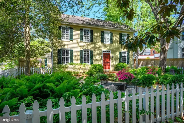 a front view of house and yard with lots of green space and plants